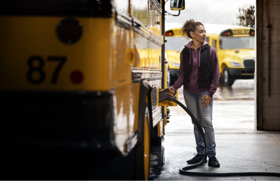 Bus driver charging electric school bus