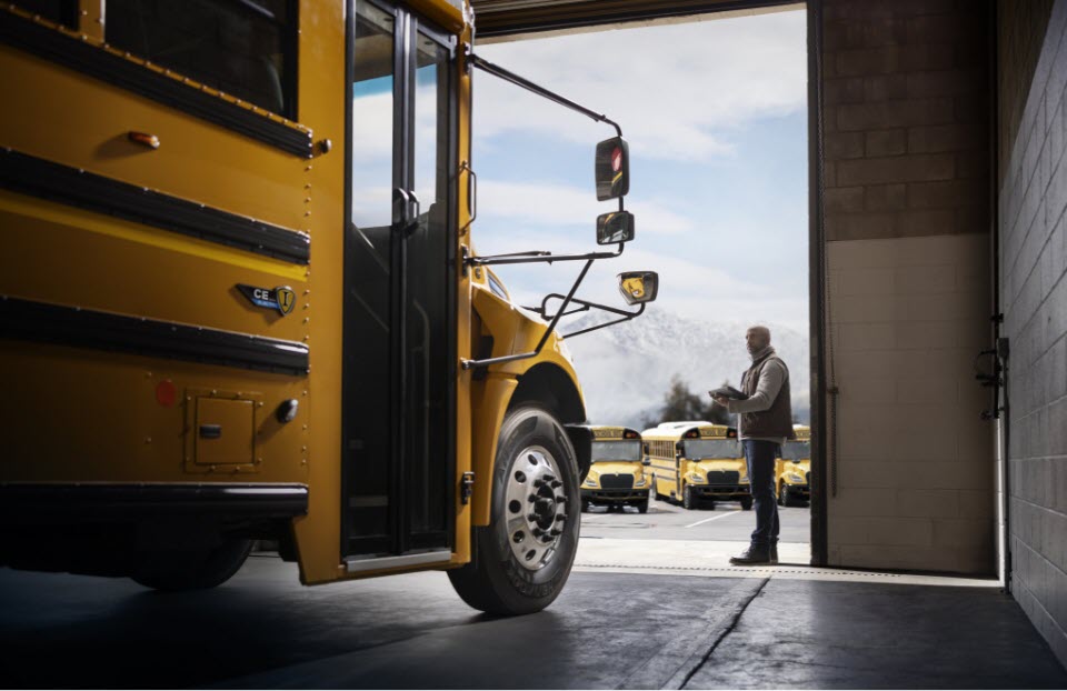 School bus in garage with man in the background