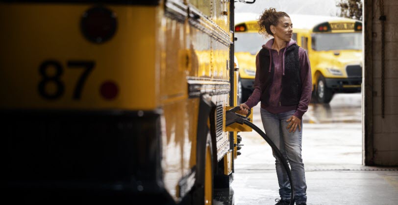 Woman fueling a school bus