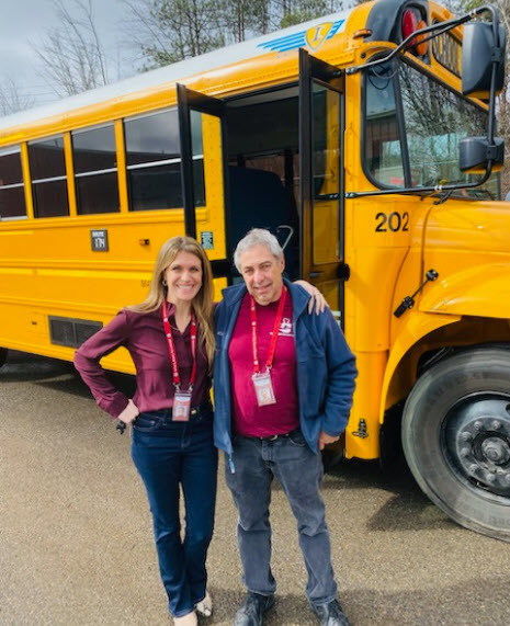 Bus driver standing in front of bus