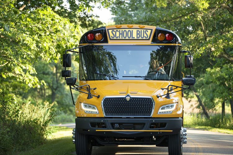 Diesel IC Bus Driving Down Wooded Road