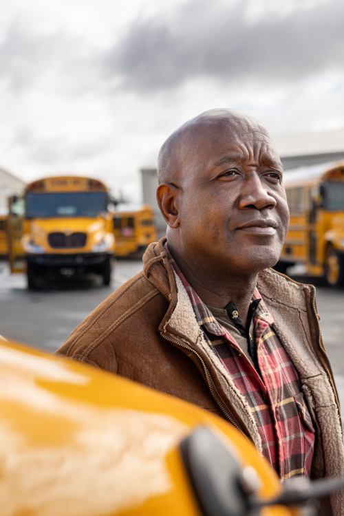 <img src="https://www.icbus.com/-/media/Project/Navistar/ICBus/ICBus/Blog/2026/A-History-of-Innovation/ICB26-School-Bus-Innovation-Blog-hero-mobile.jpg?h=750&iar=0&w=500&rev=0cd66bd860cd40b3a93d2013d3e13eaa&hash=02C04FD90A13A3FE705621E3637C6F0D" alt="A person standing in a school bus lot" width="500" height="750" />