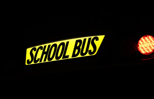 Illuminated School Bus sign on black background