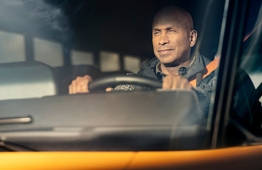Man driving bus looking out front windshield