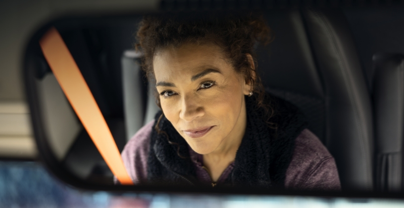 Bus driver looking in rearview mirror